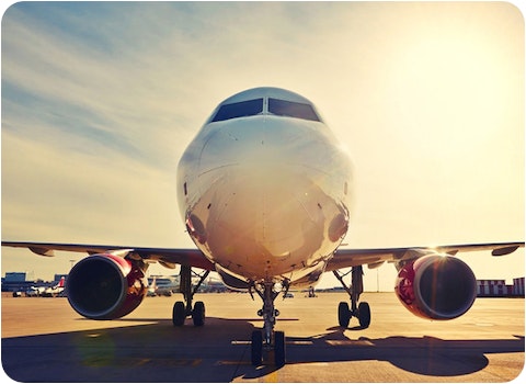 front view of aeroplane on runway in morning sun