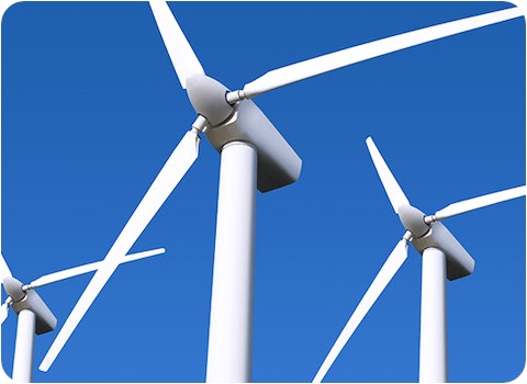 top section of 3 wind turbines against blue sky