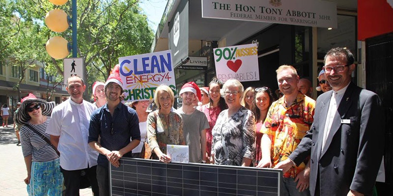 christians holding solar panel and positive solar signs in front of tony abbott's office