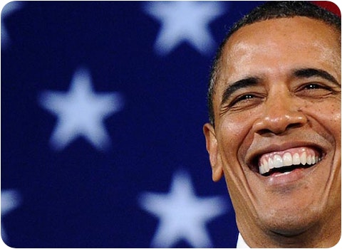 Barrack Obama smiling in front of American flag
