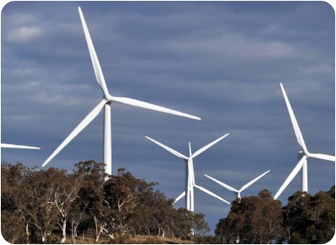 6 wind turbines mounted in woods with grey sky background