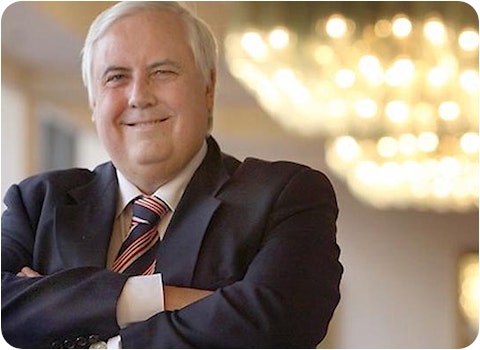 clive palmer in a suit with arms crossed looking happy