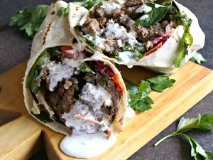 Doner kebab made with lamb and drizzled with tzatziki sauce