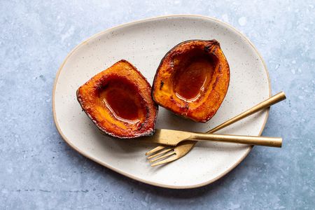 Baked Acorn Squash on a plate with a knife and fork 