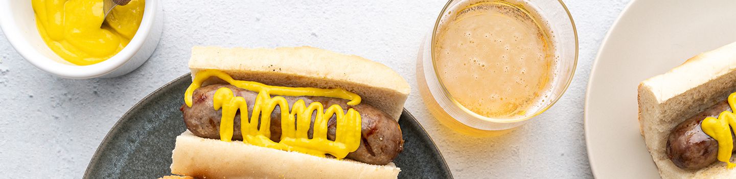 Grilled beer-braised bratwurst with a glass of beer