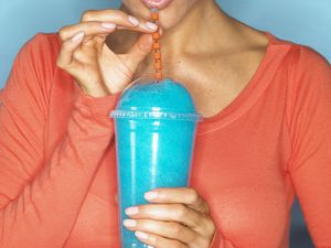 Woman drinking a blue raspberry slushie