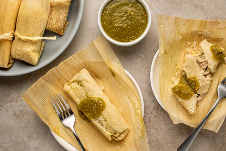 Chicken Tamales on plates, served with sauce 