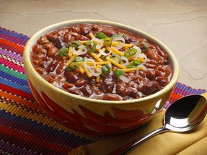 Close up of a bowl of chili on colorful plate mat