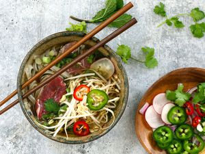 Bowl of Instant Pot beef pho with garnishes.
