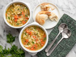 Two bowls of Instant Pot chicken and rice soup with crusty French bread.