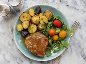 Pork chops and potatoes on a plate with salad