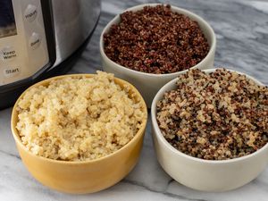 a variety of quinoa colors in bowls next to an instant pot pressure cooker