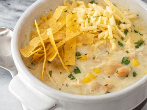 bowl of instant pot white chicken chili with tortilla strips and cheese