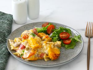 King Ranch chicken casserole with salad on a plate.
