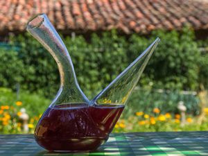 A glass porron filled with wine