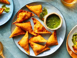 Samosa on a platter with a side of sauce 