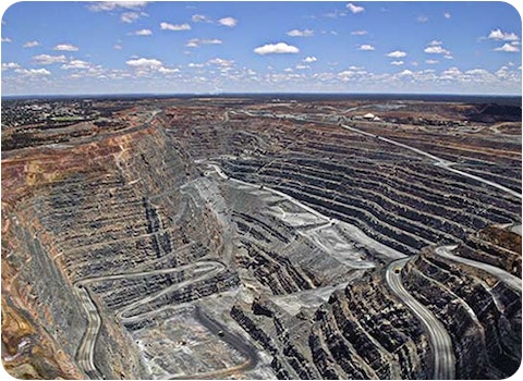 open cut coal mine with cloudy sky on horizon