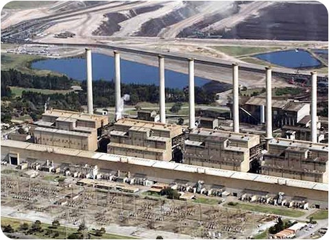 elevated view of coal fired power plant with coal mine in the distance