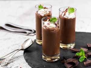 Chocolate pudding shots with whipped cream and mint