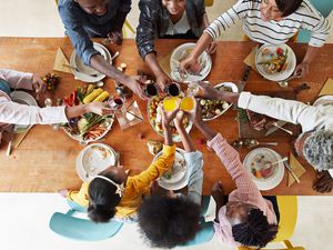 Family saying cheers over dinner table
