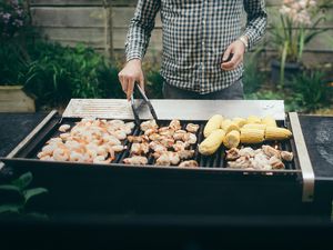 Man Grilling Chicken, Corn and Shrimp