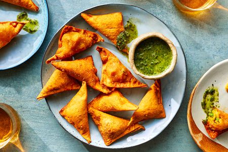 Samosa on a platter with a side of sauce 